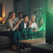 Grupo de amigos assistindo TV juntos e se divertindo.