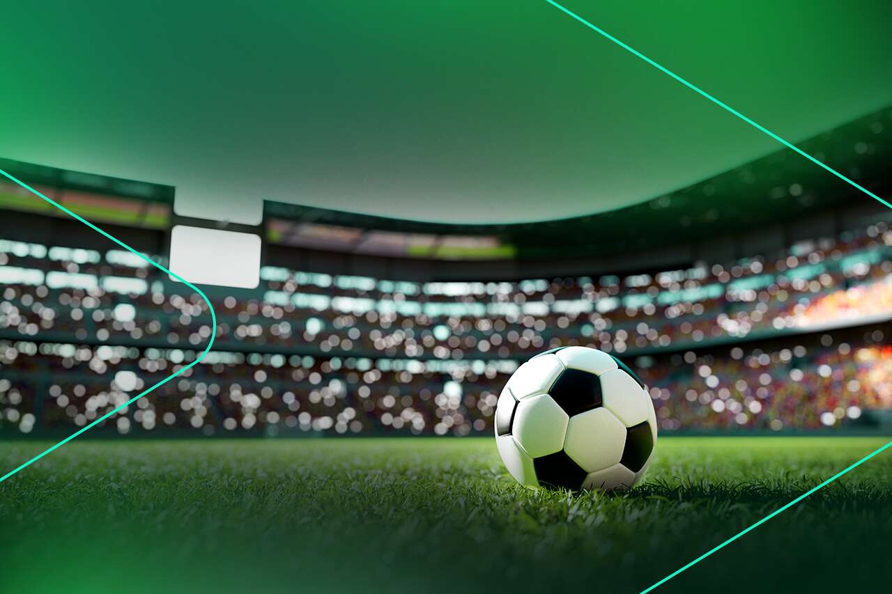 Bola de futebol em campo de estádio iluminado