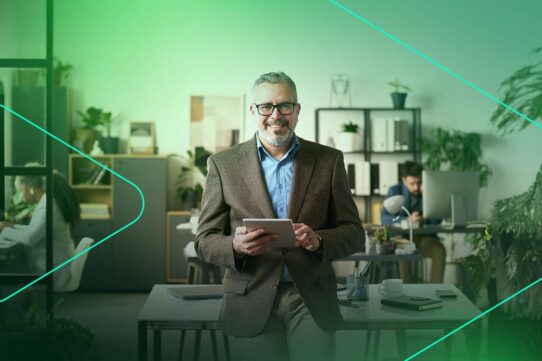 Homem sorridente em escritório moderno com tablet.