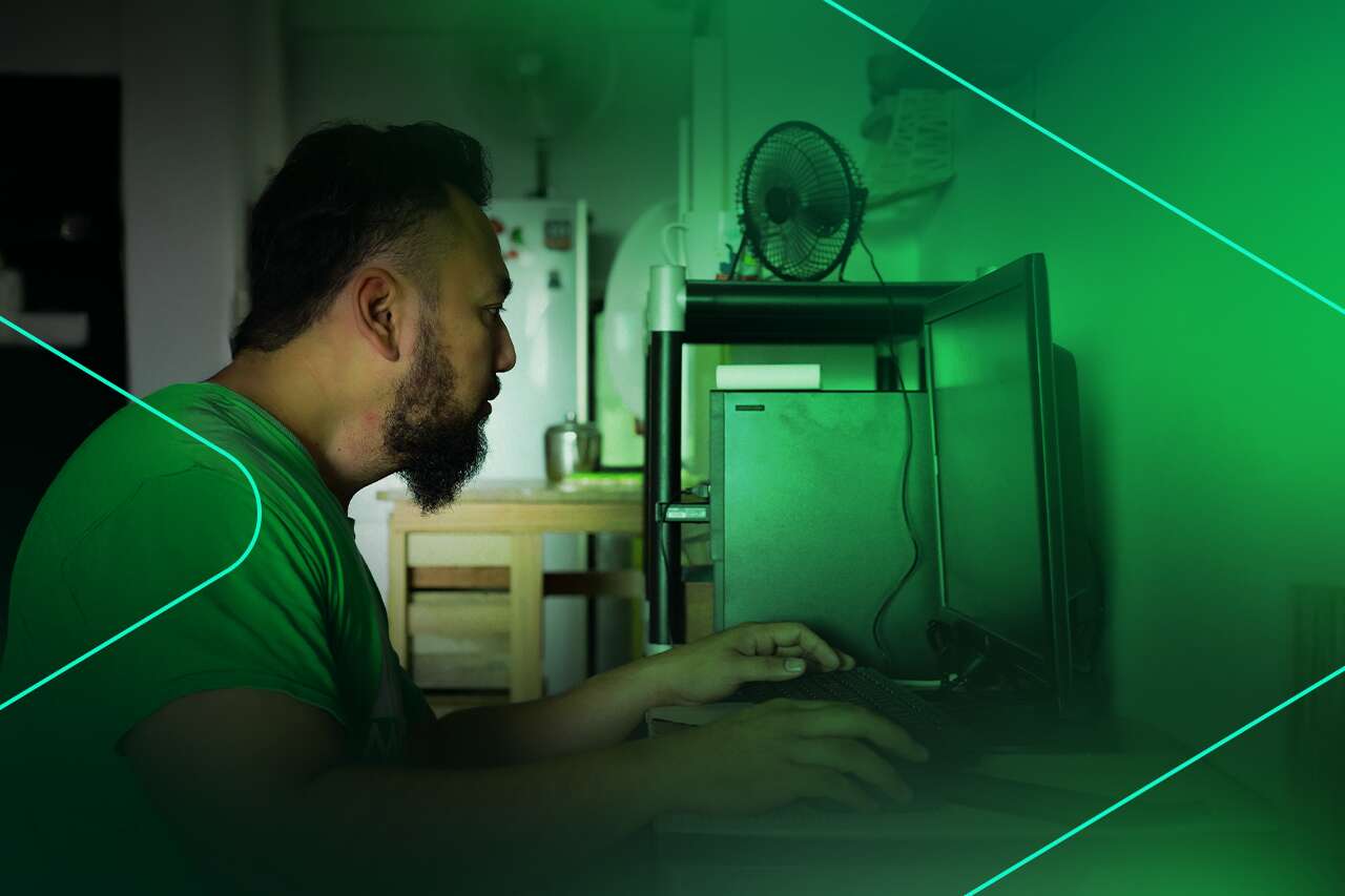 Homem trabalhando em computador em ambiente doméstico
