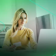 Mulher usando laptop e cartão de crédito em casa
