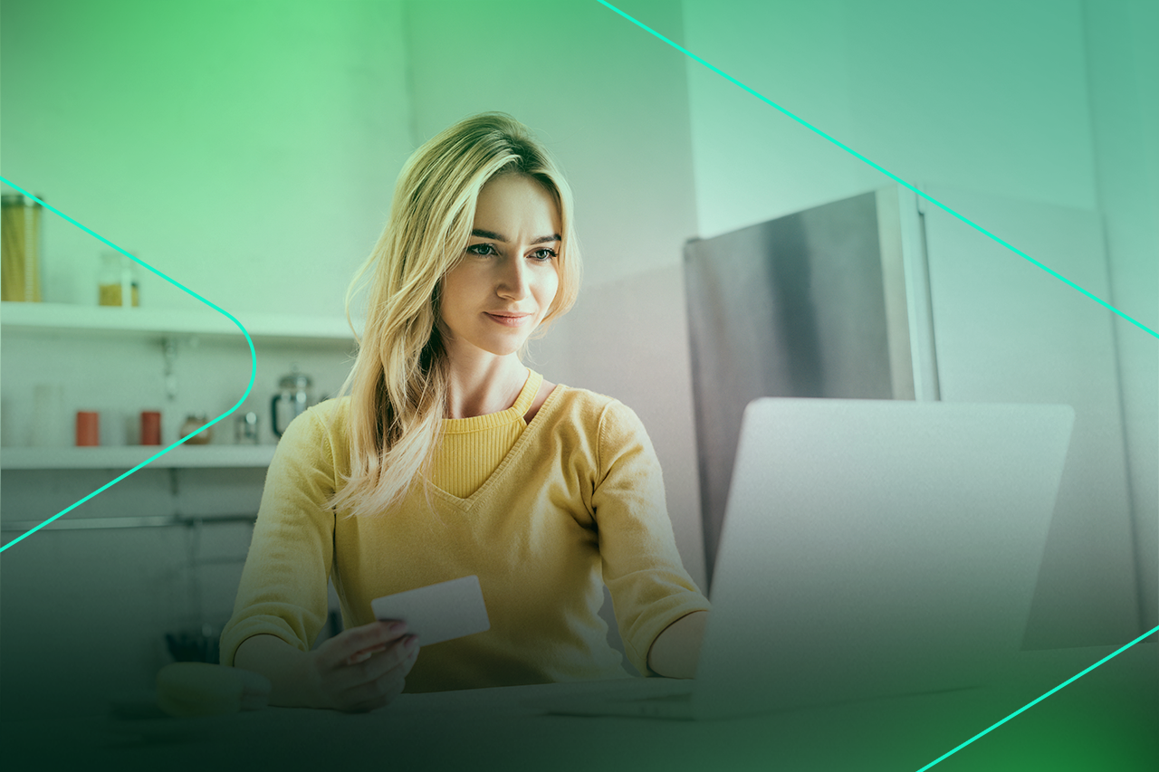 Mulher usando laptop e cartão de crédito em casa