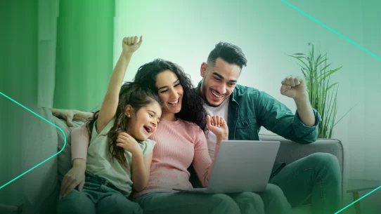 Família feliz comemorando assistindo no computador