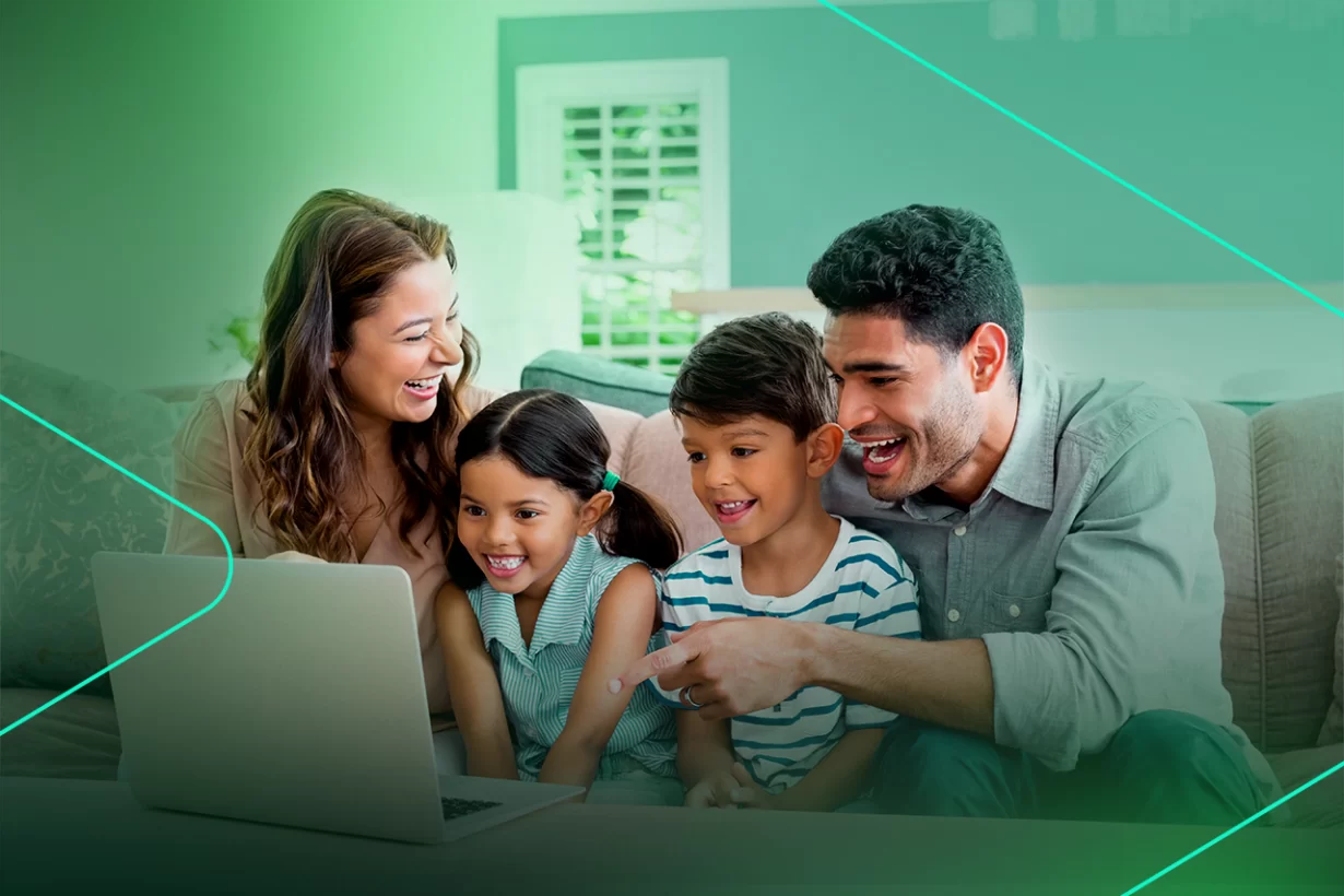 Família sorridente assistindo algo em um laptop
