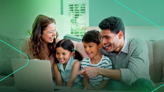 Família sorridente assistindo algo em um laptop