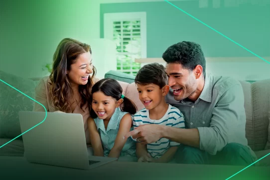 Família sorridente assistindo algo em um laptop