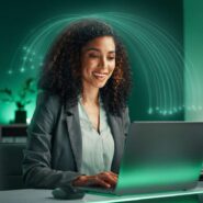 Mulher sorrindo usando laptop em ambiente moderno