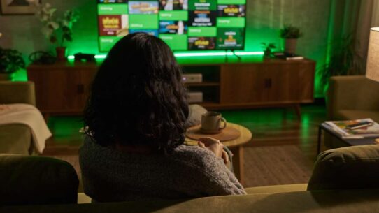 Pessoa assistindo TV em ambiente confortavel.