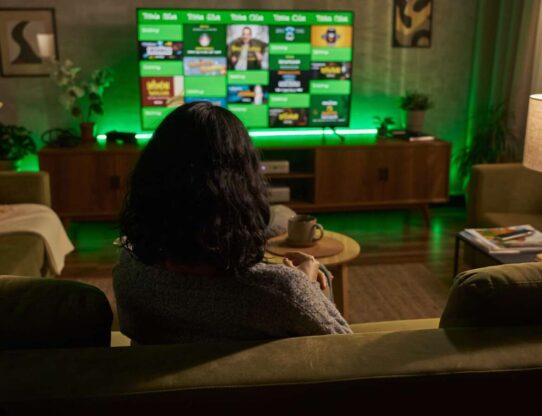 Pessoa assistindo TV em ambiente confortavel.