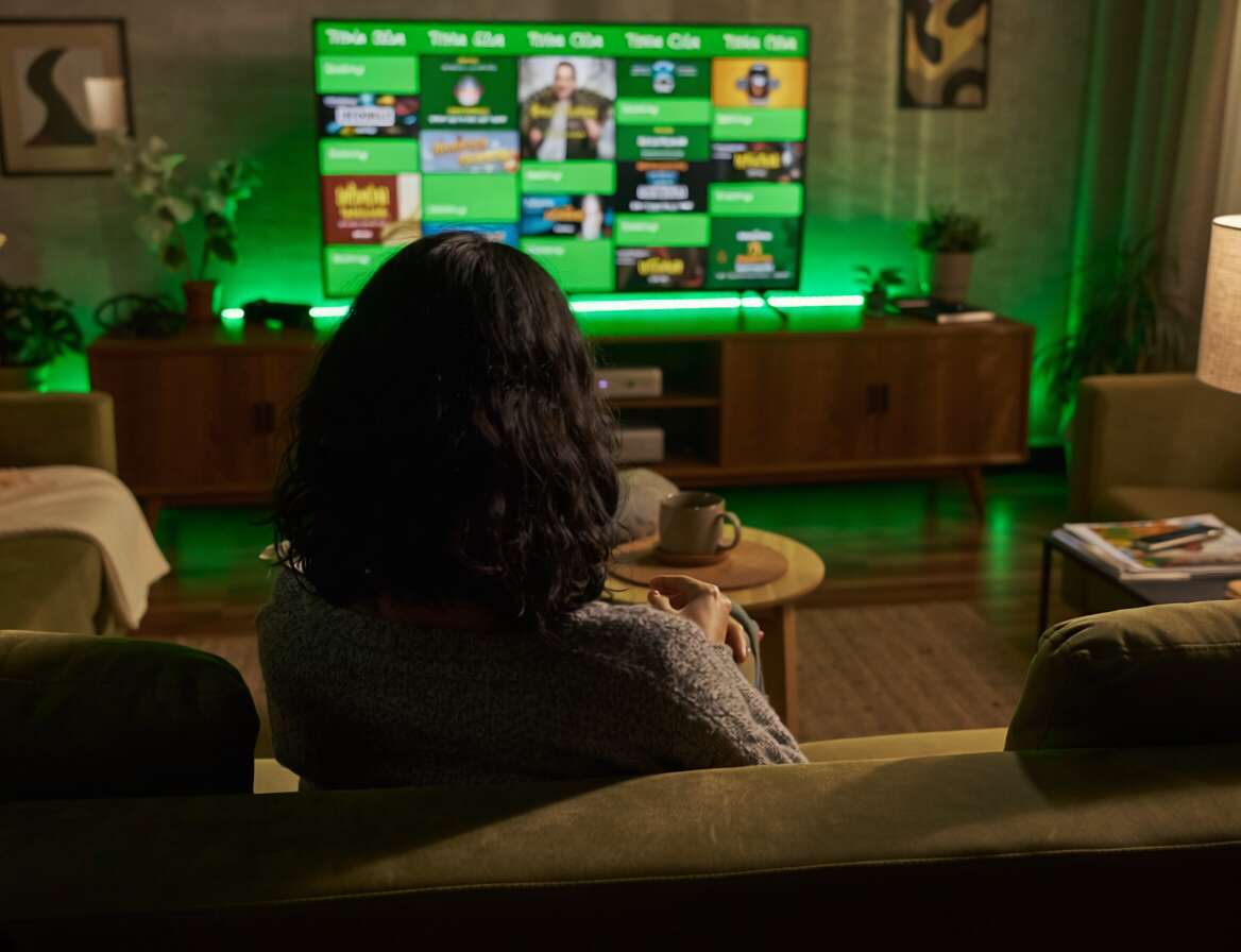 Pessoa assistindo TV em ambiente confortavel.