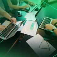 Grupo de pessoas reunidas trabalhando com notebooks