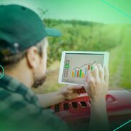 Homem analisando gráficos de dados agrícolas em tablet.