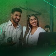 Casal sorrindo e interagindo com um notebook