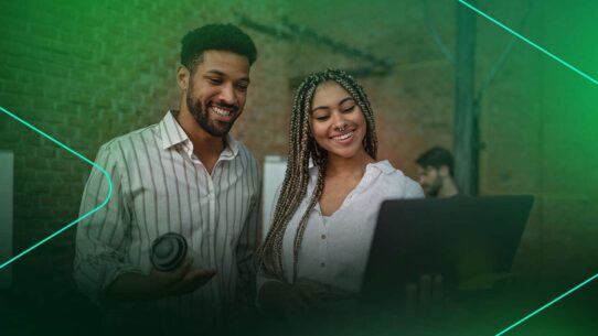 Casal sorrindo e interagindo com um notebook