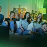 Grupo de amigos se divertindo assistindo TV