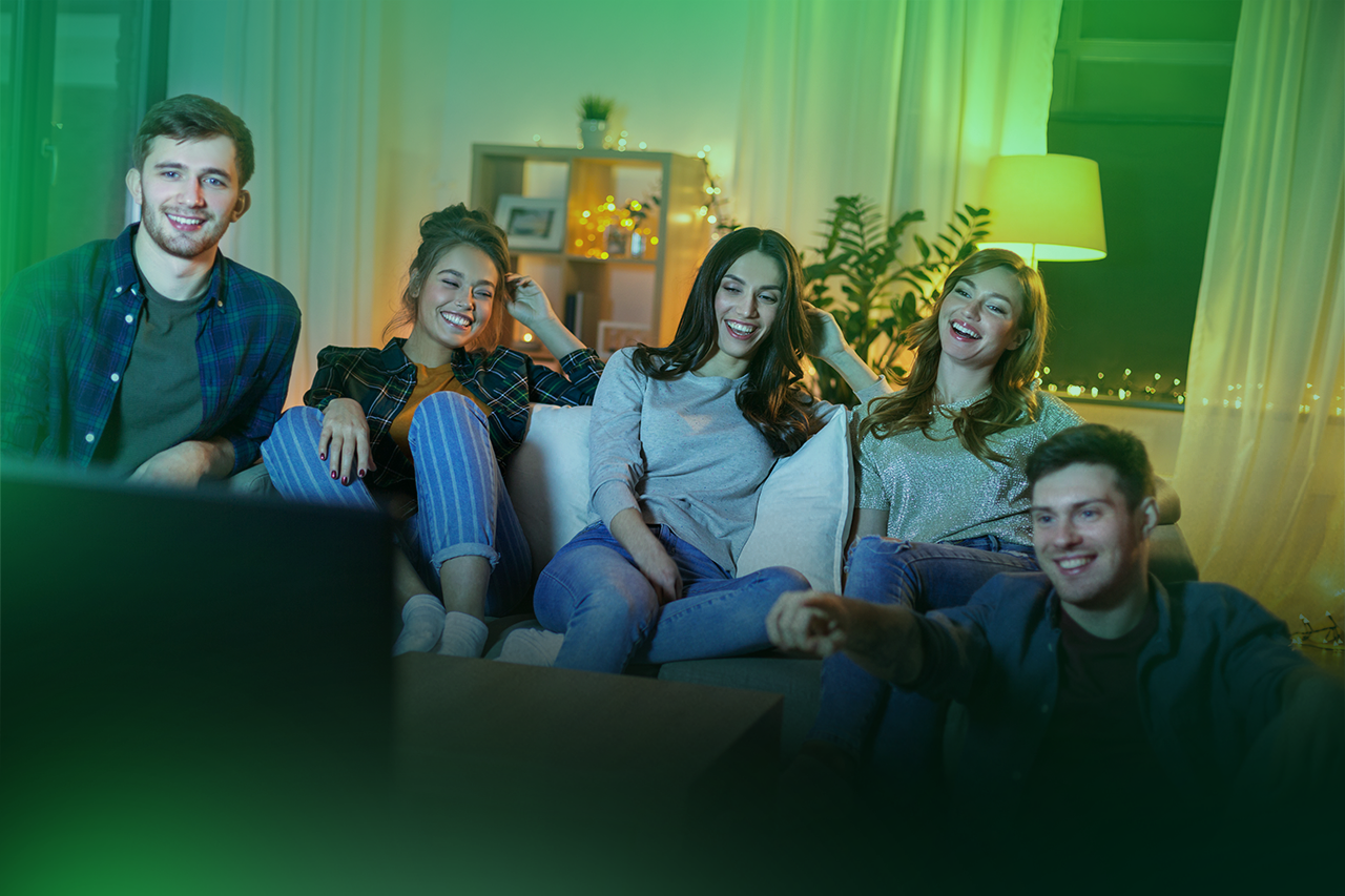 Grupo de amigos se divertindo assistindo TV