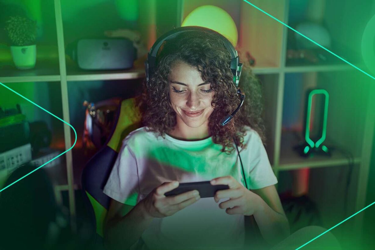 Jovem jogando no celular com fones de ouvido