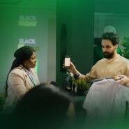 Atendente mostra smartphone em loja durante Black Friday