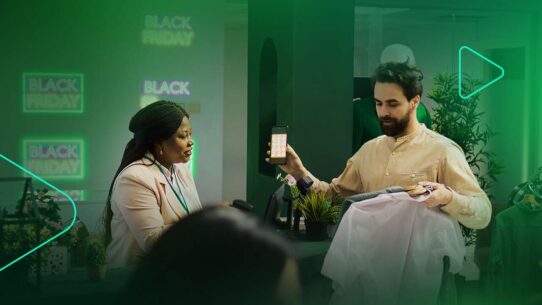 Atendente mostra smartphone em loja durante Black Friday