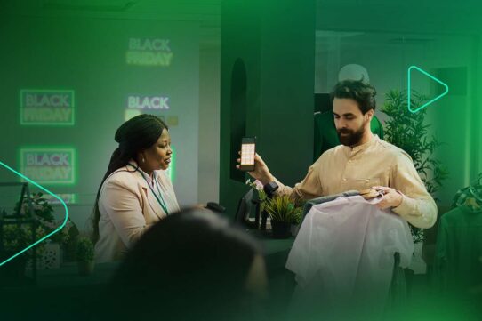 Atendente mostra smartphone em loja durante Black Friday
