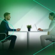 Dois profissionais em videoconferência em mesa de trabalho.