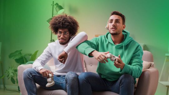 Dois amigos jogando videogame no sofá