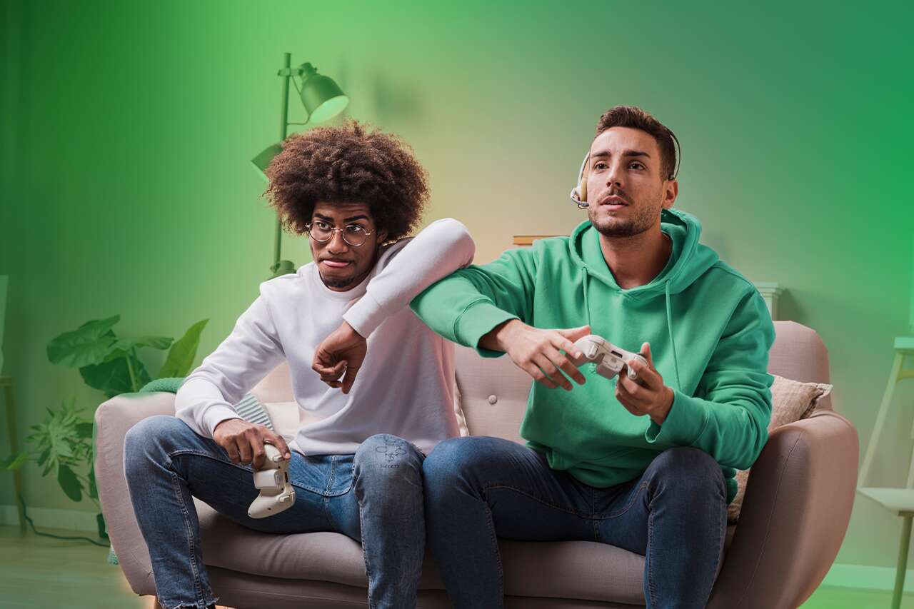 Dois amigos jogando videogame no sofá