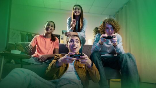 Grupo de amigos jogando videogame juntos em casa.