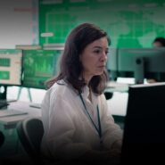 Mulher trabalhando em ambiente de análise financeira.