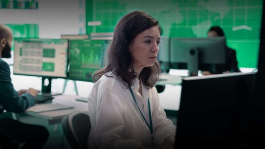 Mulher trabalhando em ambiente de análise financeira.