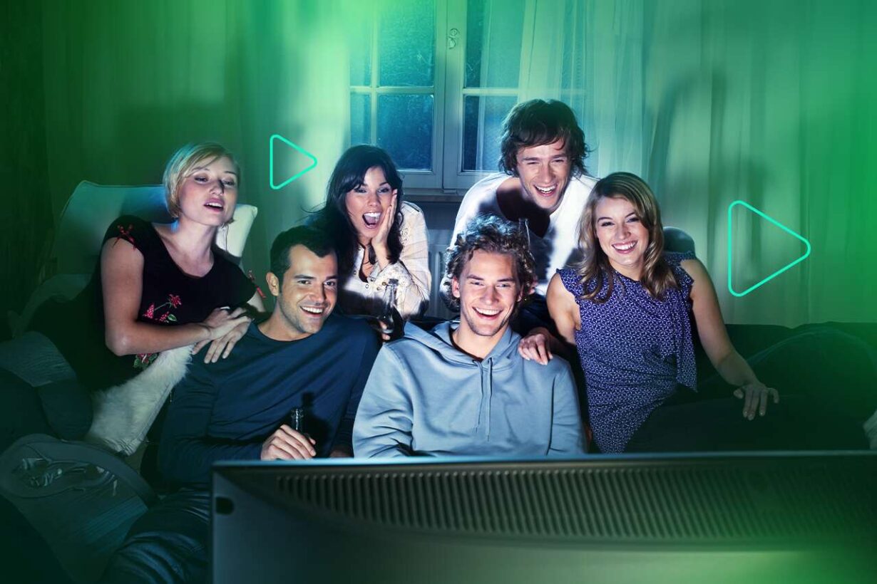 Grupo de amigos assistindo TV e se divertindo