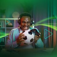 Homem sorridente jogando futebol em um videogame.