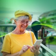Mulher idosa sorrindo enquanto usa smartphone