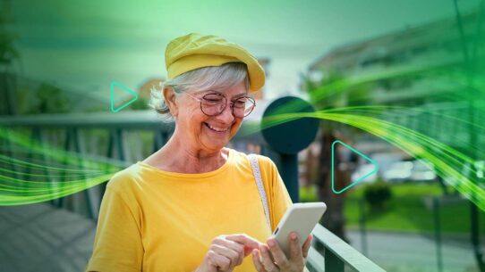 Mulher idosa sorrindo enquanto usa smartphone