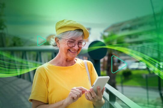 Mulher idosa sorrindo enquanto usa smartphone