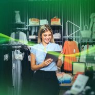 Mulher sorrindo em loja de roupas usando tablet