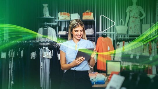 Mulher sorrindo em loja de roupas usando tablet