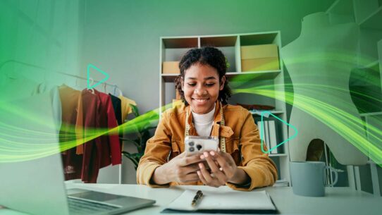 Mulher sorridente usando smartphone em ambiente criativo