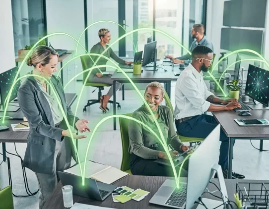 Colaboradores em escritório moderno com tecnologia conectada.