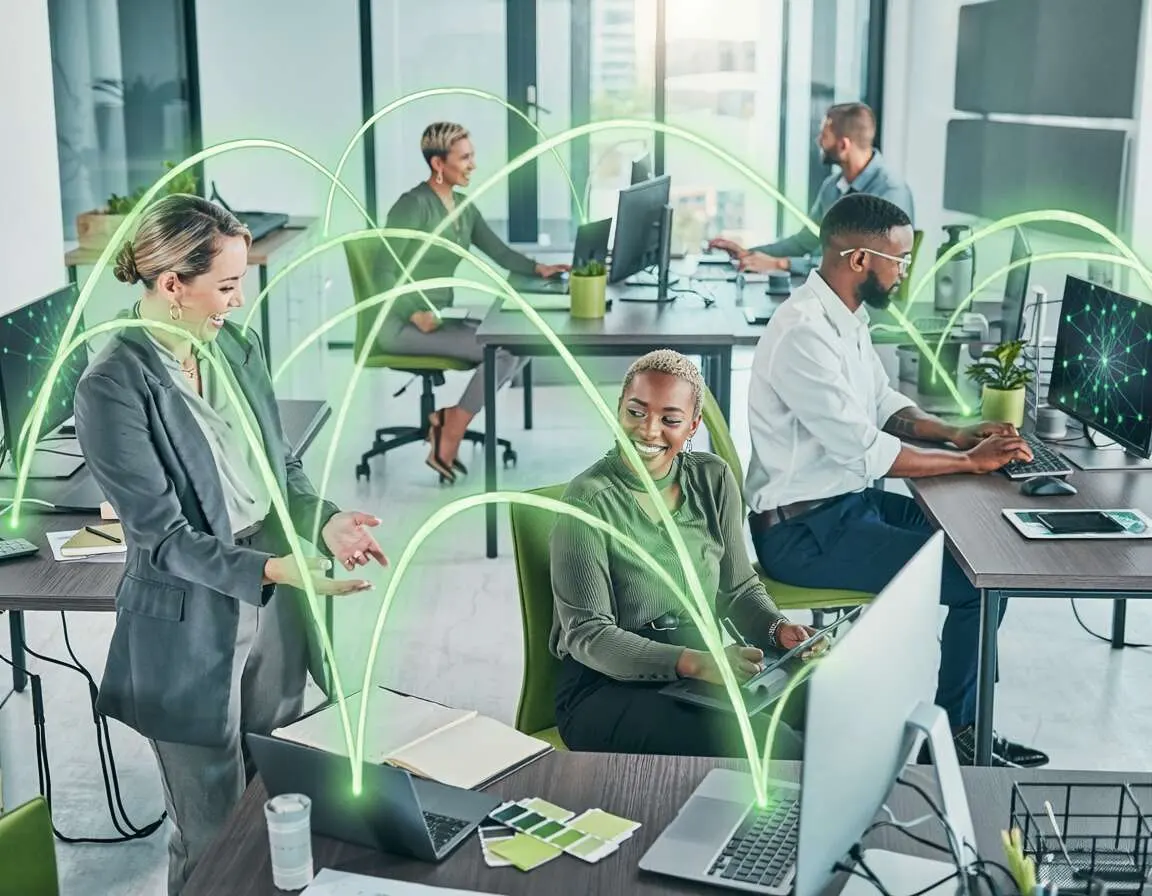 Colaboradores em escritório moderno com tecnologia conectada.