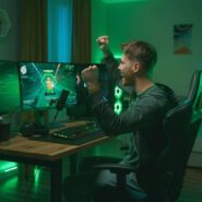 Jovem comemorando vitória em jogo de computador.