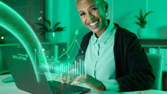 Mulher sorrindo com gráfico de crescimento no laptop.