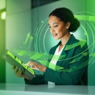 Mulher usando tablet com gráficos digitais e setas verdes.