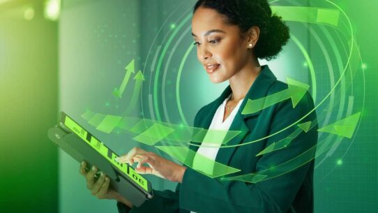 Mulher usando tablet com gráficos digitais e setas verdes.