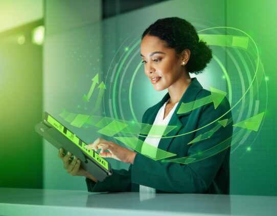 Mulher usando tablet com gráficos digitais e setas verdes.
