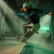 Skatista manobrando em uma pista interna iluminada.