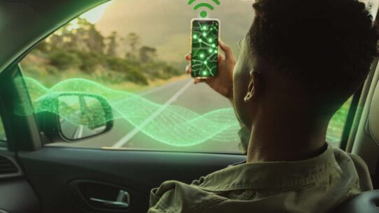 Homem usando smartphone em carro com sinal de Wi-Fi.