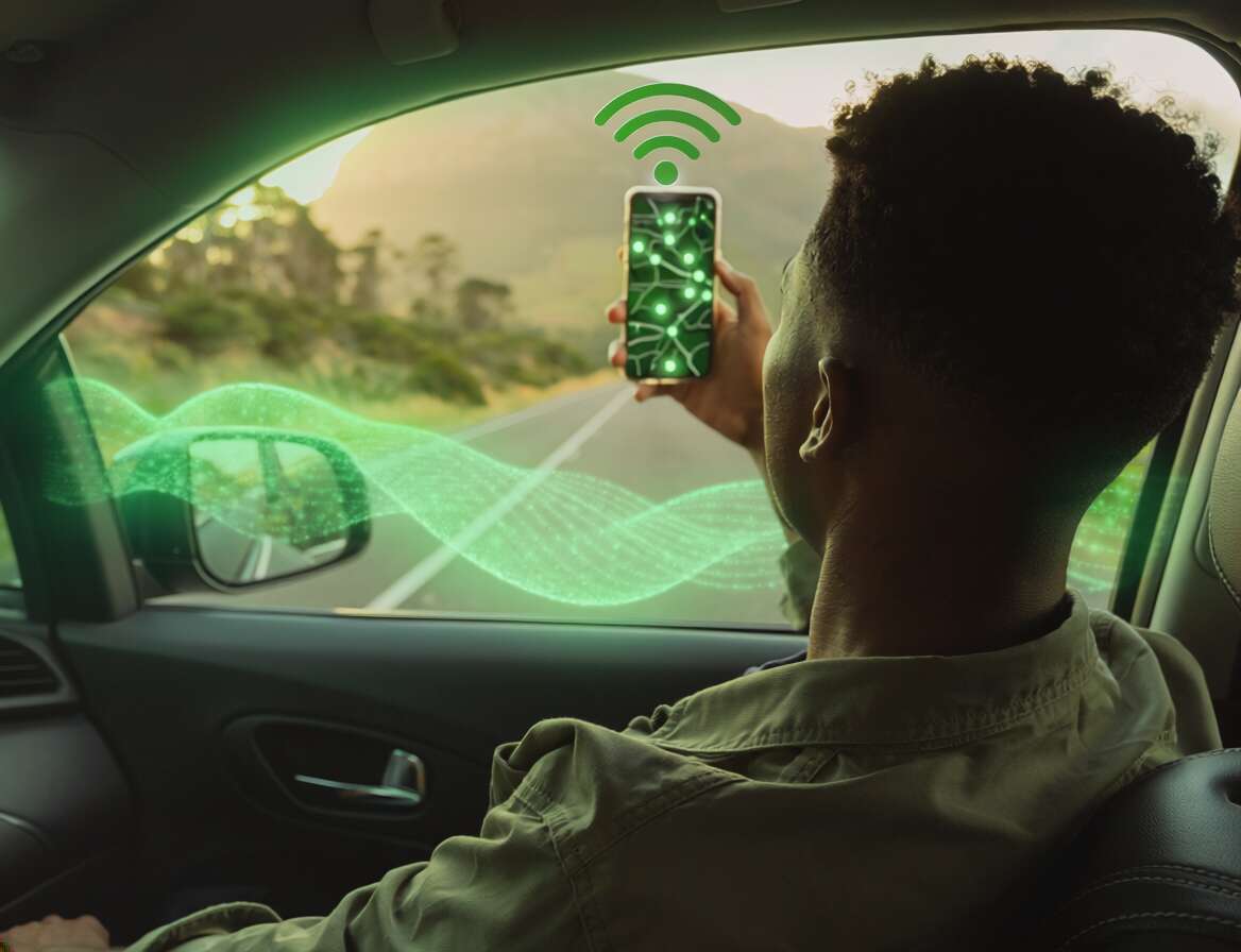Homem usando smartphone em carro com sinal de Wi-Fi.