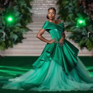 Modelo com vestido verde em evento glamouroso.