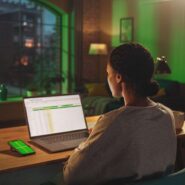 Pessoa trabalhando em laptop com planilha à noite.
